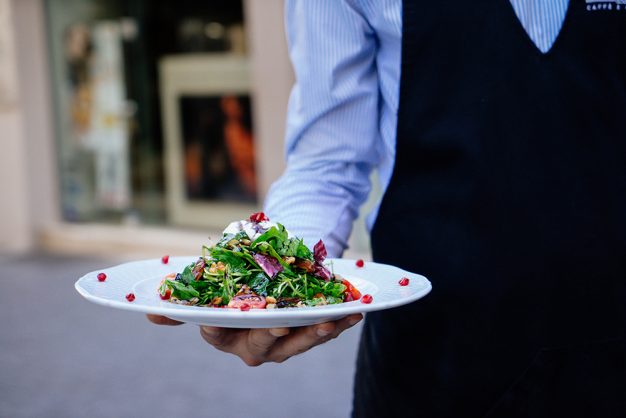 Waiter holding plate of food